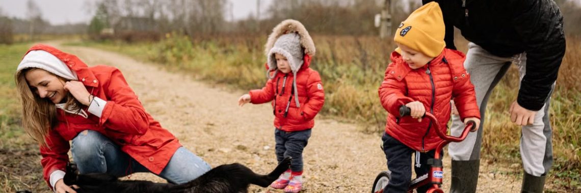Happy family enjoying quality time outdoors with kids and dog in countryside.